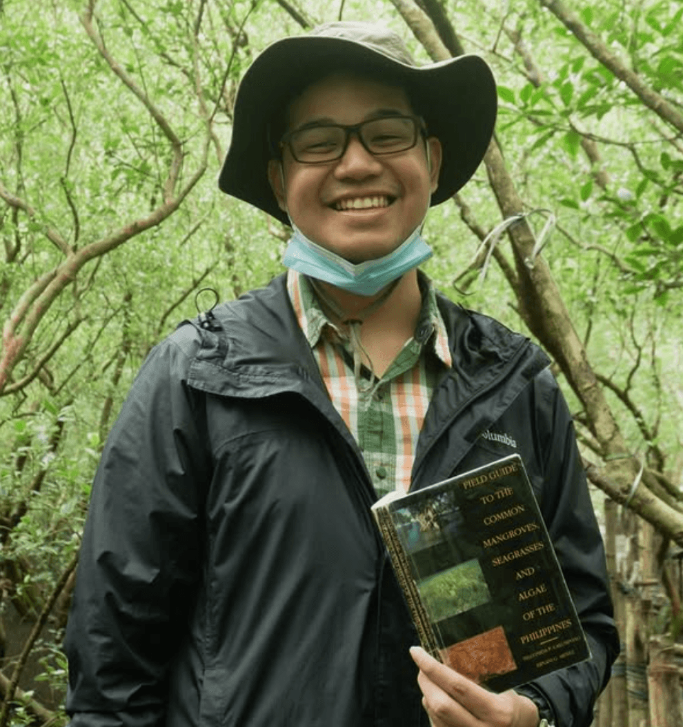 Matthew out in the fields, brandishing his field guide to common mangroves